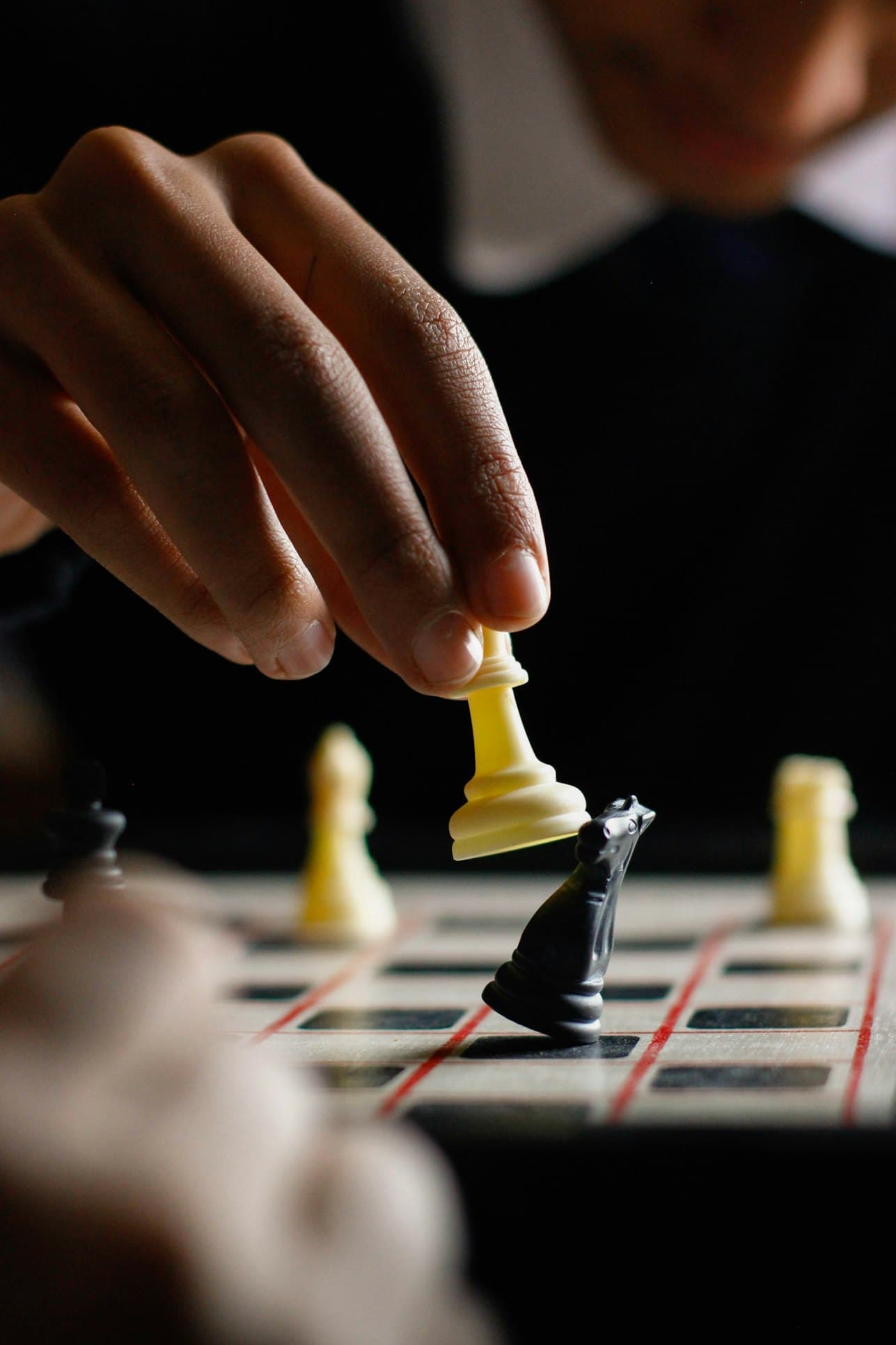 A photograph of a chess game, a player is taking a night with it's white pawn.