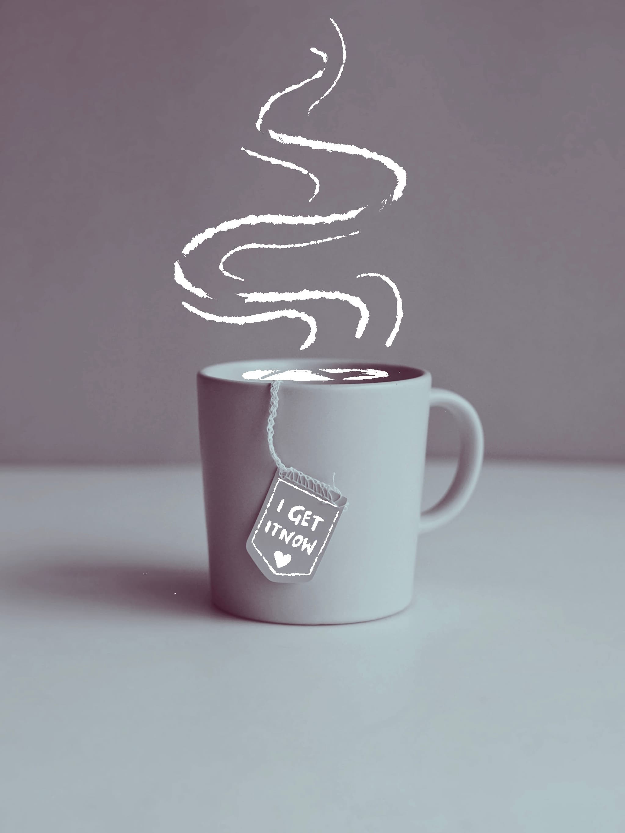 A pale blush ceramic mug set against a dusty blue backdrop, a yellow tea-bag tag hanging over the rim by its string, soft indirect light.