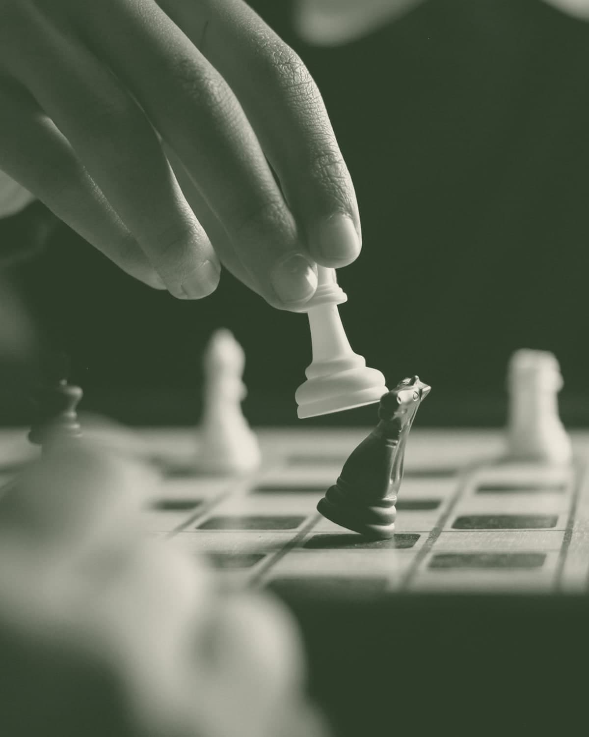 A photograph of a chess game, a player is taking a night with it's white pawn.