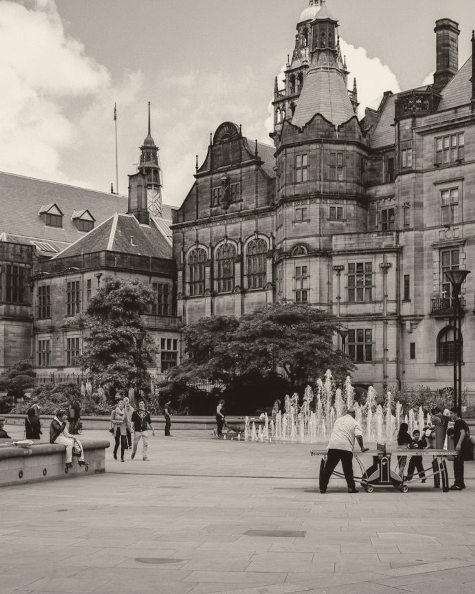 Sheffield Town Hall and the Peace Gardens fountains, with people gathered in the square